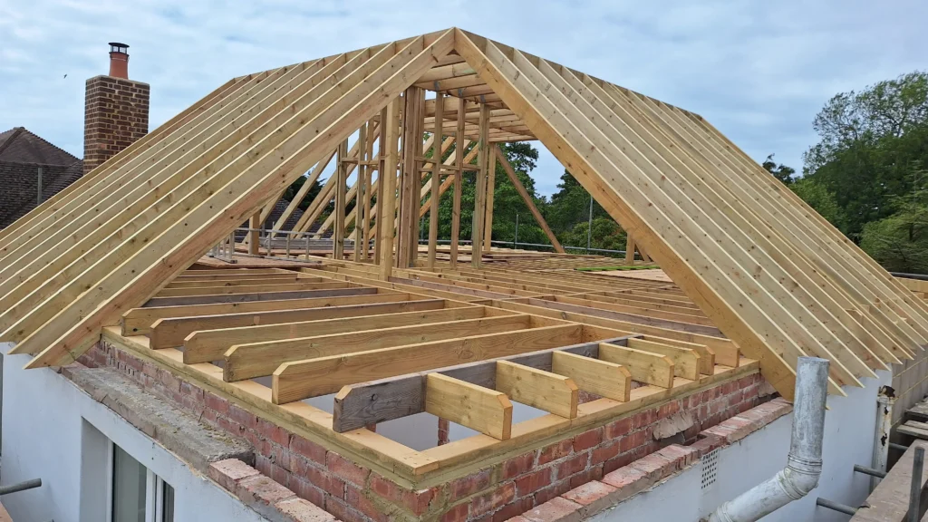 Custom timber roof framing in progress, awaiting the fitting of the hip and jack rafters