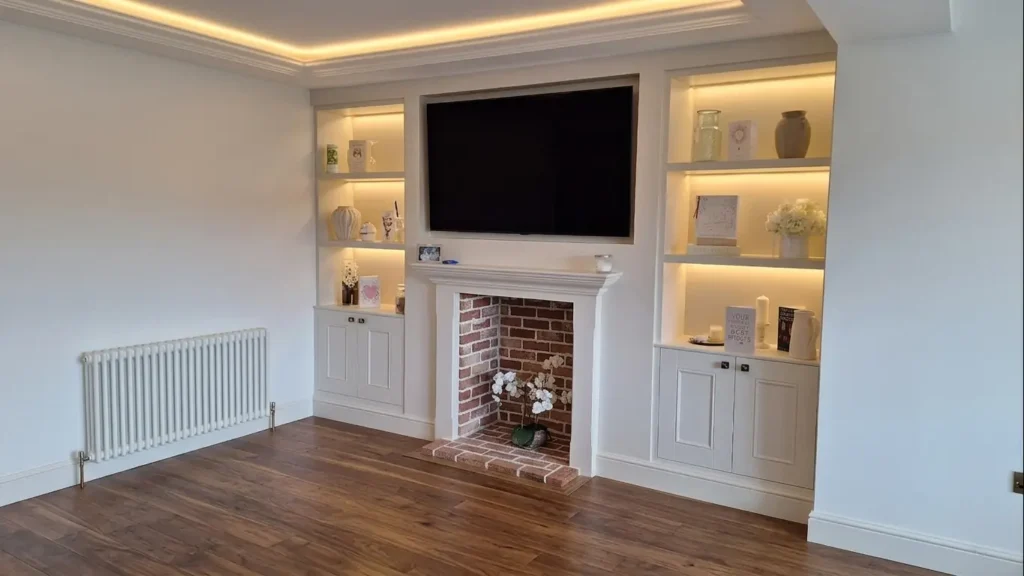 Bespoke white media wall with integrated fireplace, shelving, and walnut hardwood flooring done in Bexhill-on-sea