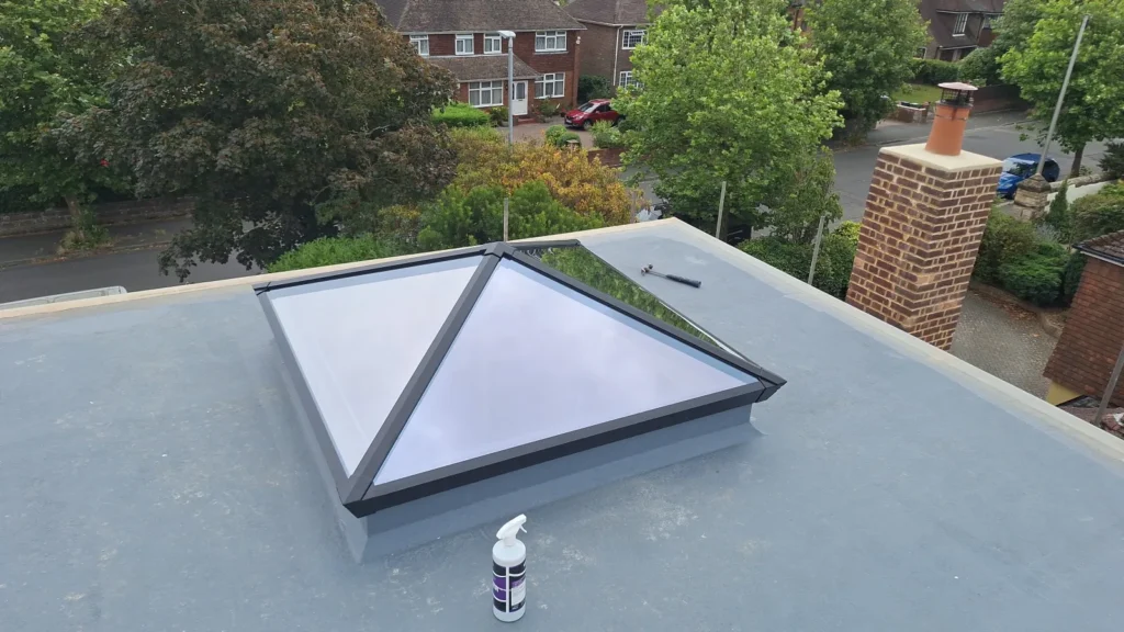 Professional installation of a large metal roof lantern on a flat roof extension, featuring clean internal joinery and expansive glass panels to maximise natural light in Hastings, East Sussex.