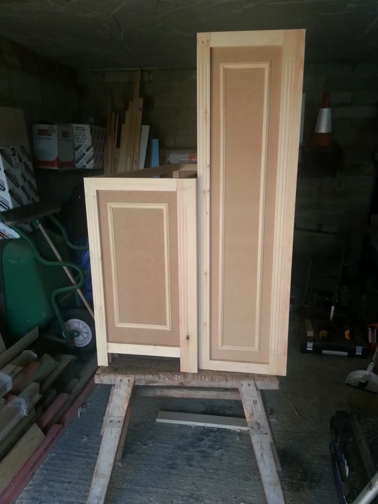 Completed lower and upper units of the library cabinet with fluted details and decorative trim ready for final assembly.