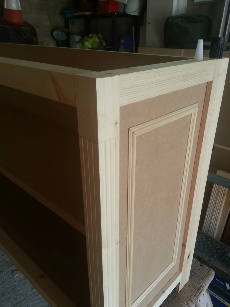 Close-up of the decorative fluted timber uprights and elegant inset panel moulding on the cabinet exterior.